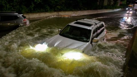 A motorist drives a car through a flooded expressway in Brooklyn, New York.