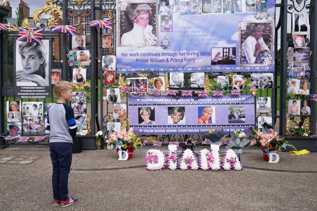 People view tributes left at the gates of Kensington Palace in London on the 24th anniversary of the death of Diana, Princess of Wales. 