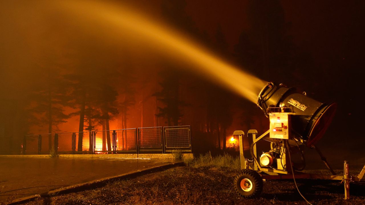 A snow machine blows water on a structure at Sierra-at Tahoe ski resort as the Caldor Fire moves through the area on August 30, 2021 in Twin Bridges, California.