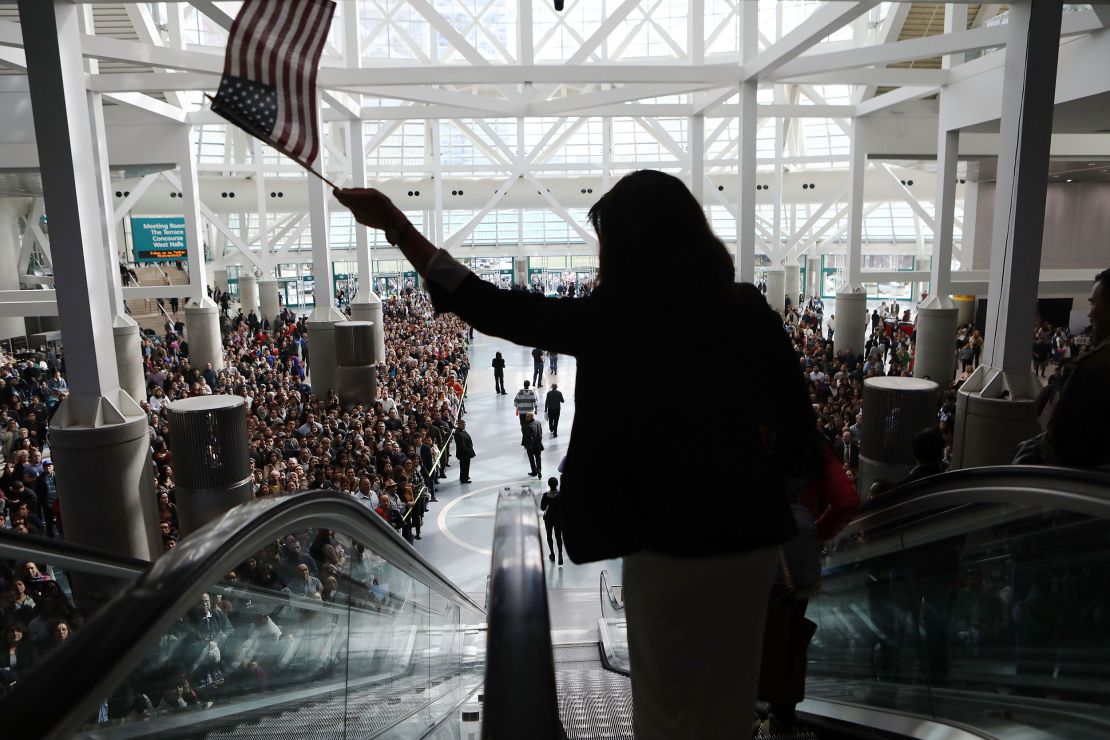 A new US citizen waves an American flag while departing a naturalization ceremony on March 20, 2018, in Los Angeles.