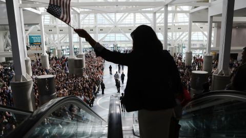 A new US citizen waves an American flag while departing a naturalization ceremony on March 20, 2018, in Los Angeles.
