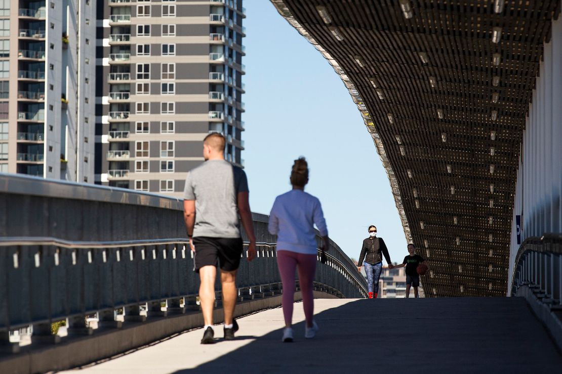 Local residents walk over a bridge on August 4 in Brisbane, Australia.