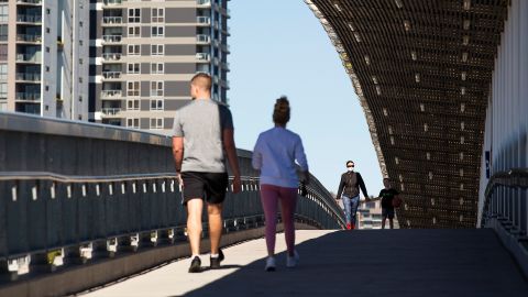 Local residents walk over a bridge on August 4 in Brisbane, Australia.