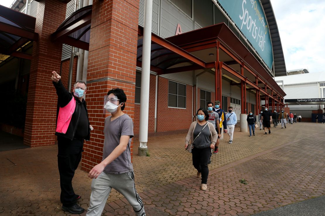 A staff member directs people on arrival to the Qudos Bank Arena NSW Health Vaccination Centre on August 27 in Sydney, Australia.
