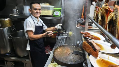 Singaporean chef Chan Hon Meng prepares meals for customers at his Hong Kong Soya Sauce Chicken Rice and Noodle stall in Singapore on July 22, 2016.