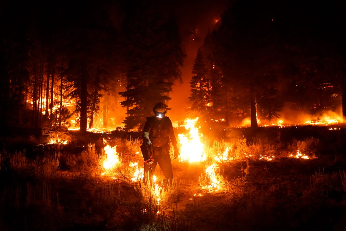 A firefighter lights a backfire to stop the Caldor Fire from spreading near South Lake Tahoe on September 1, 2021. 