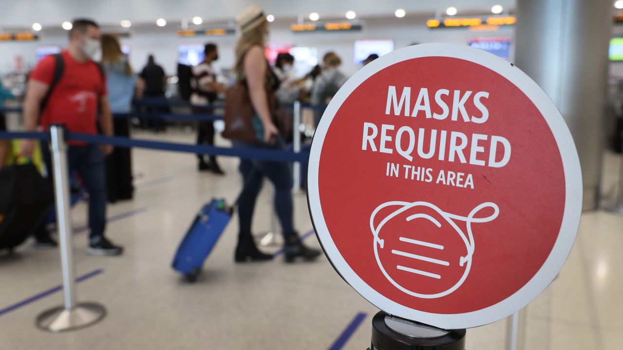 A sign reading "masks required in this area" is seen as travelers prepare to check-in for their Delta Airlines flight at the Miami International Airport on February 1, 2021.