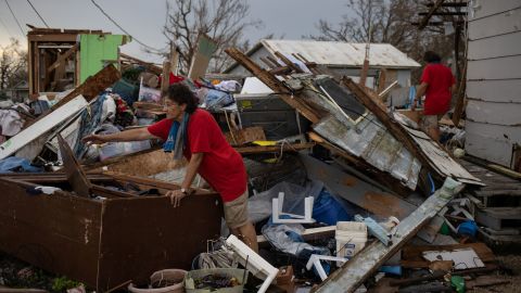Twin sisters Bridget and Rosalie Serigny, 66, search for personal items stored in their destroyed shed in Golden Meadow, Louisiana, on Wednesday.