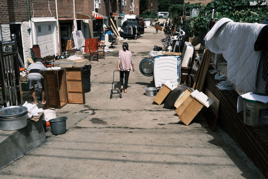 People clean up their flooded homes in a neighborhood in Queens, New York, that saw massive flooding and numerous deaths following a night of heavy wind and rain from the remnants of Hurricane Ida.