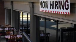 A "Now Hiring" sign stands outside a restaurant in Arlington, Virginia, on August 12, 2021. 