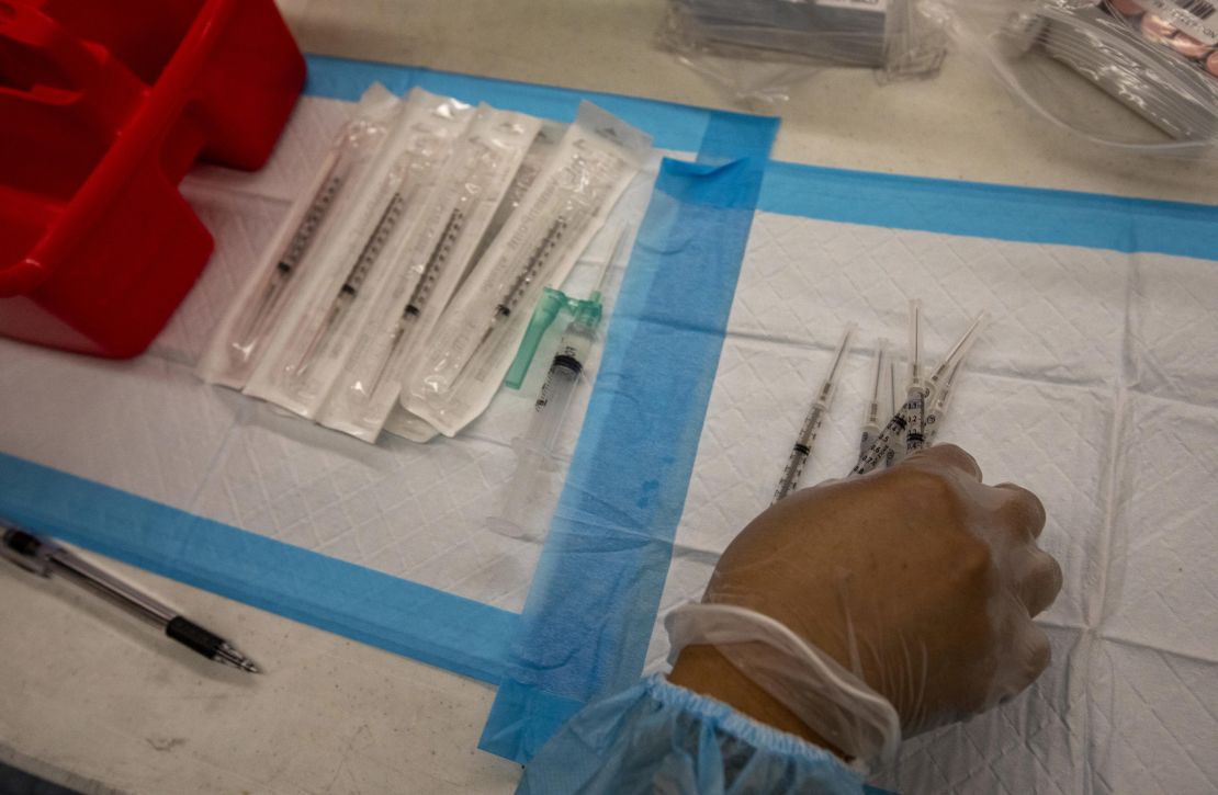 A healthcare worker prepares doses of the Pfizer-BioNTech Covid-19 vaccine at a mobile vaccination clinic at a high school in Los Angeles, California.