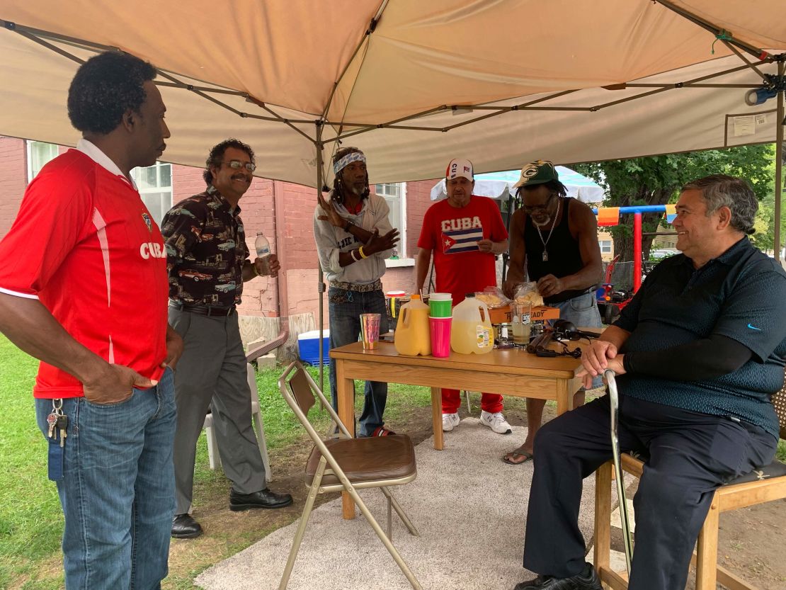 Ernesto Rodriguez, Marcos Calderon, Rodosvaldo Pozo, Osvaldo Fajardo, Norberto Gomez Mendez, and Jose Lores all sharing a meal on a weekday afternoon.