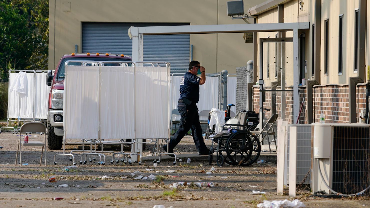 An EMS technician walks near the mass shelter in Independence, Louisiana, on September 2, 2021