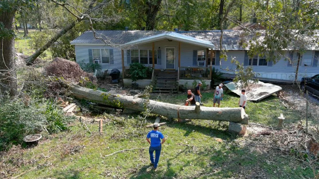 Volunteers from nearby churches came to help chop up the nearly 100 foot oak tree that killed Dennis Duplessis during Hurricane Ida.