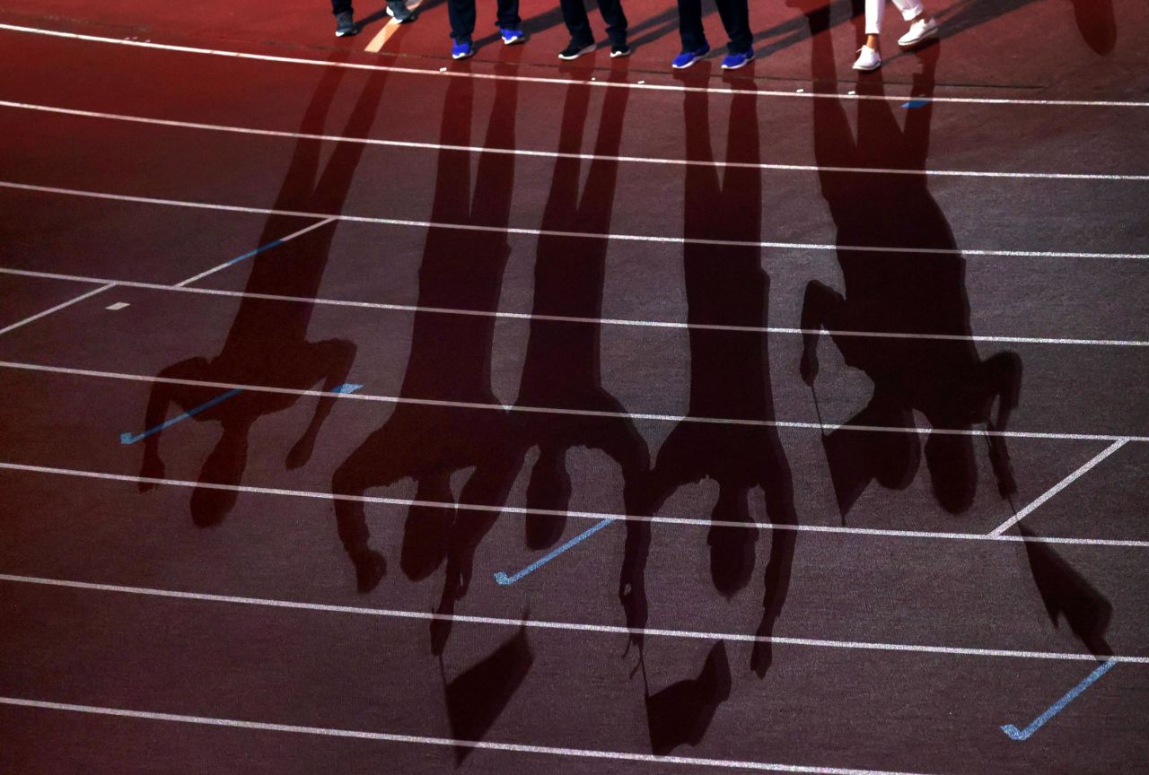 Participants' shadows are seen on the track during the closing ceremony.