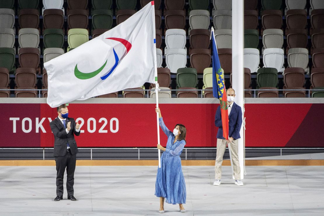 Mayor of Paris Anne Hidalgo waves the Paralympic flag at the closing ceremony as IPC president Andrew Parsons looks on.