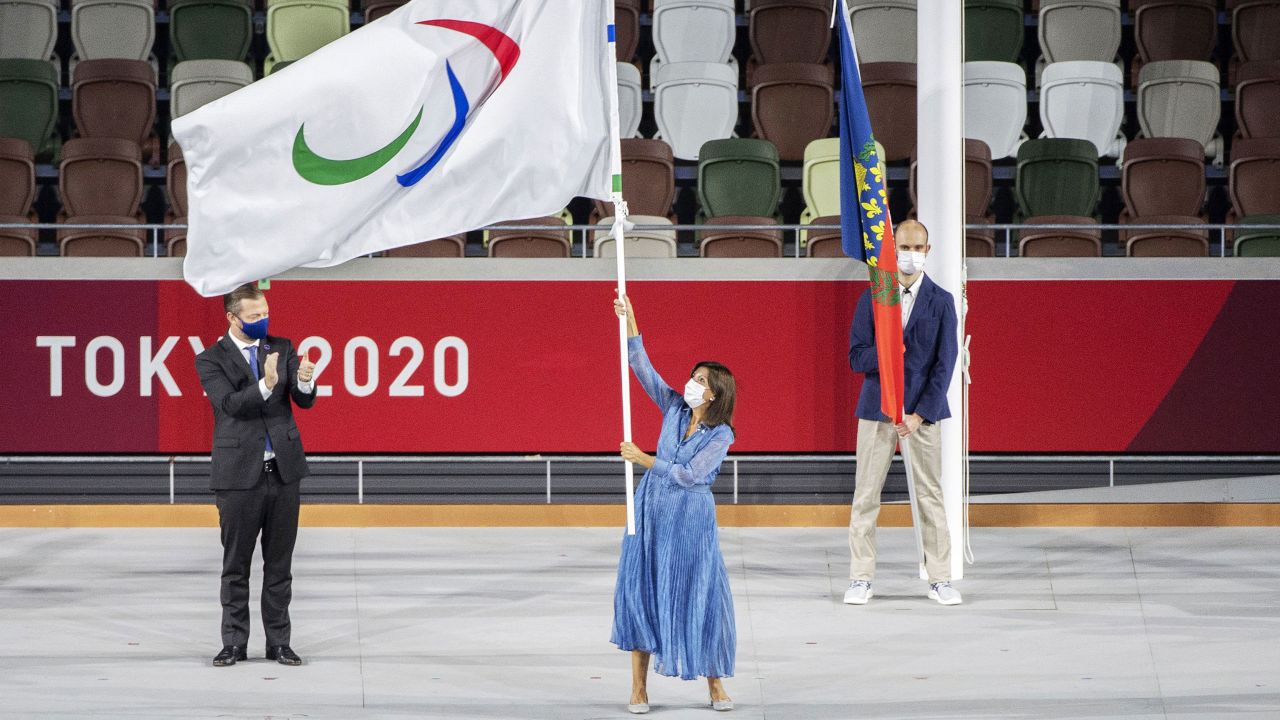 Mayor of Paris Anne Hidalgo waves the Paralympic flag at the closing ceremony as IPC president Andrew Parsons looks on.