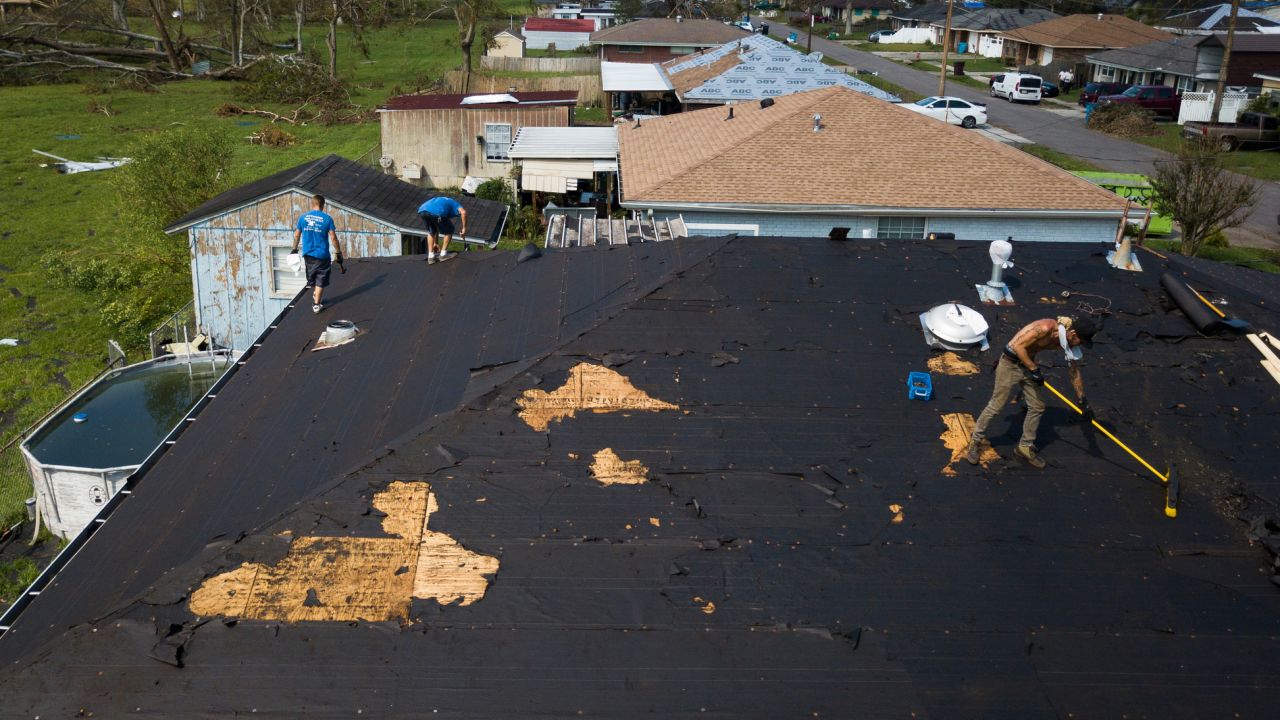 People work to repair a roof in Norco, Louisiana.