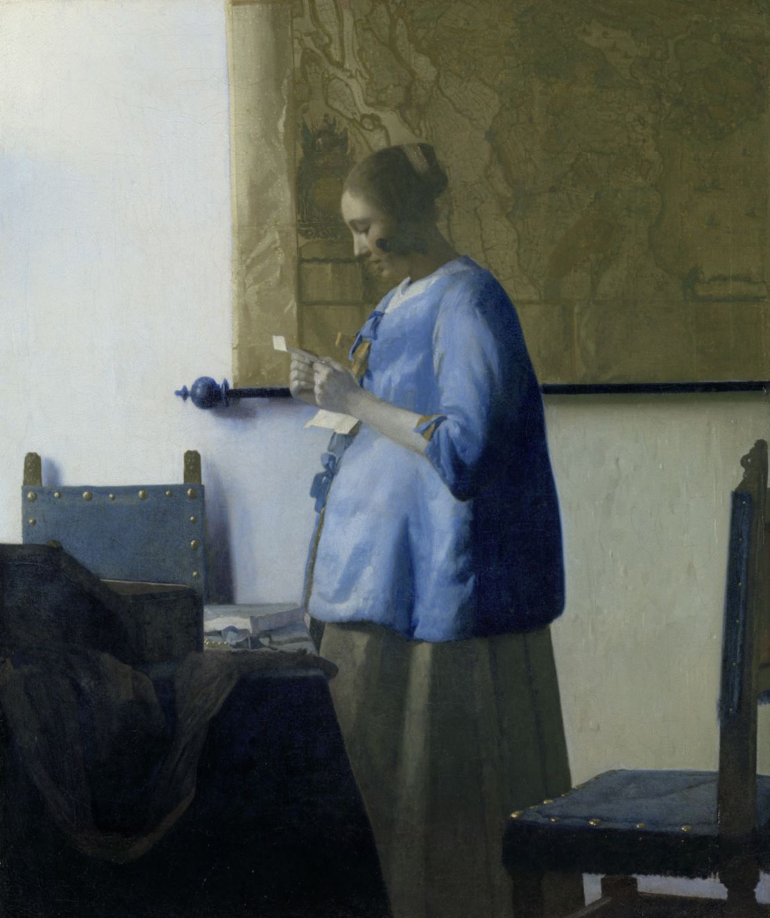 "Woman in Blue Reading a Letter" illustrates many of the same themes: a solitary figure reading a letter in a familiar domestic space, lit by the light of a window to the left.