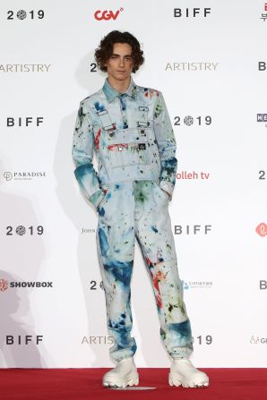 His style has maintained a sense of youthfulness, as seen with the  paint-splattered overalls (by S.R. Studio. LA. CA.) that he wore to a photocall in South Korea in 2019.