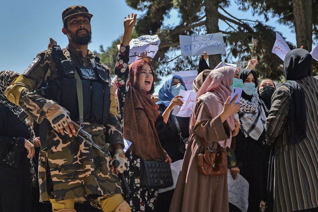 A Taliban fighter stands guard as Afghan women shout slogans during a protest in Kabul on Tuesday.