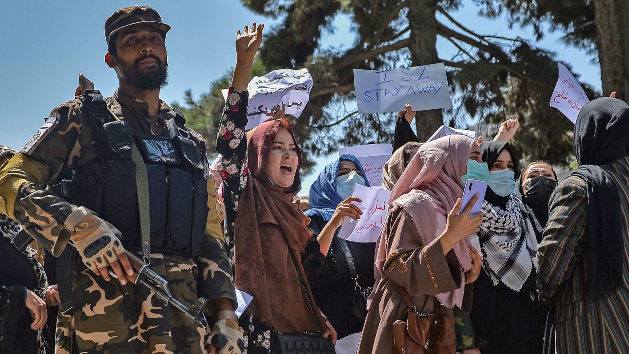 A Taliban fighter stands guard as Afghan women shout slogans during a protest in Kabul on Tuesday.