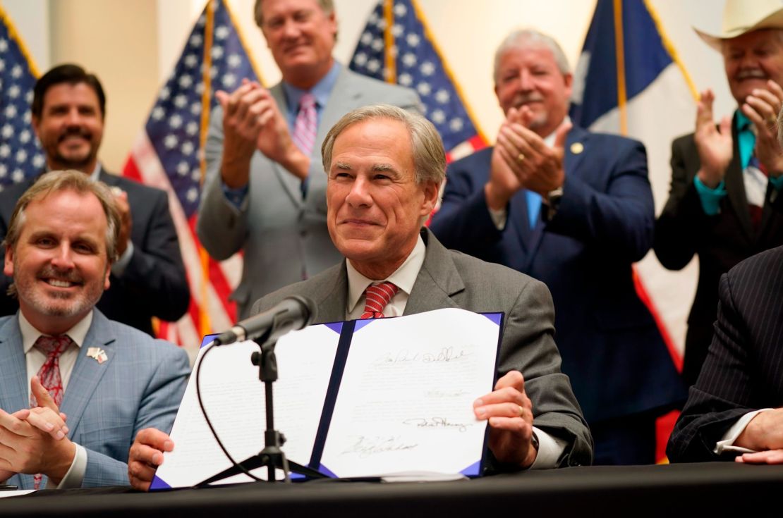 Texas Gov. Greg Abbott shows off Senate Bill 1, also known as the election integrity bill, after he signed it into law on Sept. 7, 2021.
