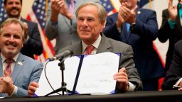 Texas Gov Greg Abbott shows off Senate Bill 1, also known as the election integrity bill, after he signed it into law in Tyler, Texas, Tuesday, Sept. 7, 2021. The sweeping bill signed Tuesday by the two-term Republican governor further tightens Texas' strict voting laws. (AP Photo/LM Otero)