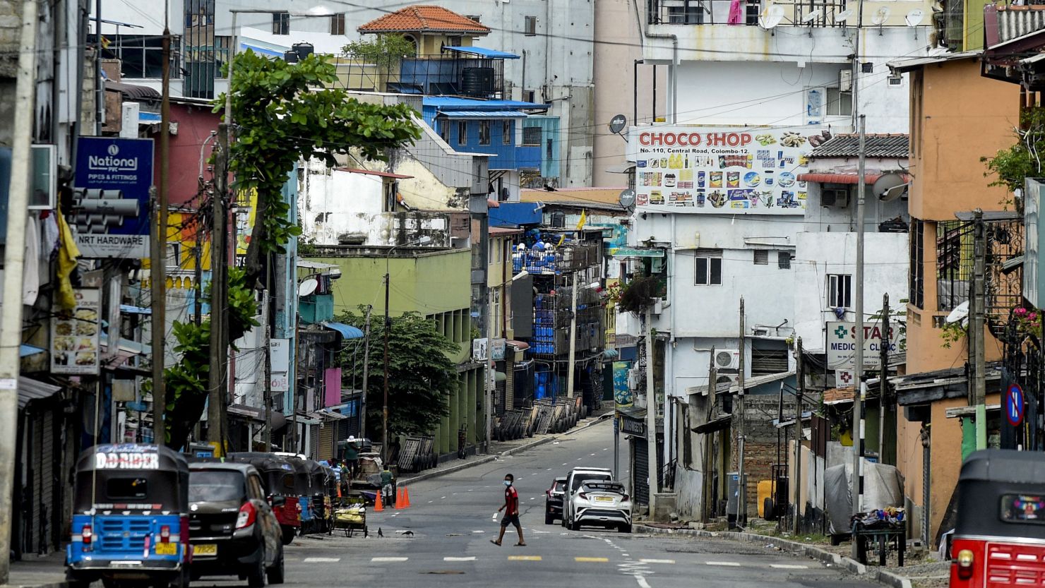 A general view shows a man crossing a deserted street during a nationwide 10-day lockdown imposed to curb the spread of Covid-19 coronavirus in Colombo on August 21, 2021. (Photo by ISHARA S. KODIKARA / AFP) (Photo by ISHARA S. KODIKARA/AFP via Getty Images)