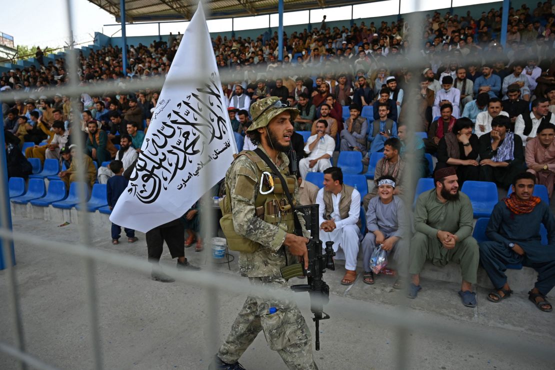 A Taliban fighter keeps vigil as spectators watch the Twenty20 cricket trial match being played between two Afghan teams 'Peace Defenders' and 'Peace Heroes' at the Kabul International Cricket Stadium in Kabul on September 3, 2021.