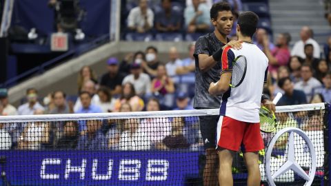 Felix Auger-Aliassime of Canada and Carlos Alcaraz of Spain meet at the net.