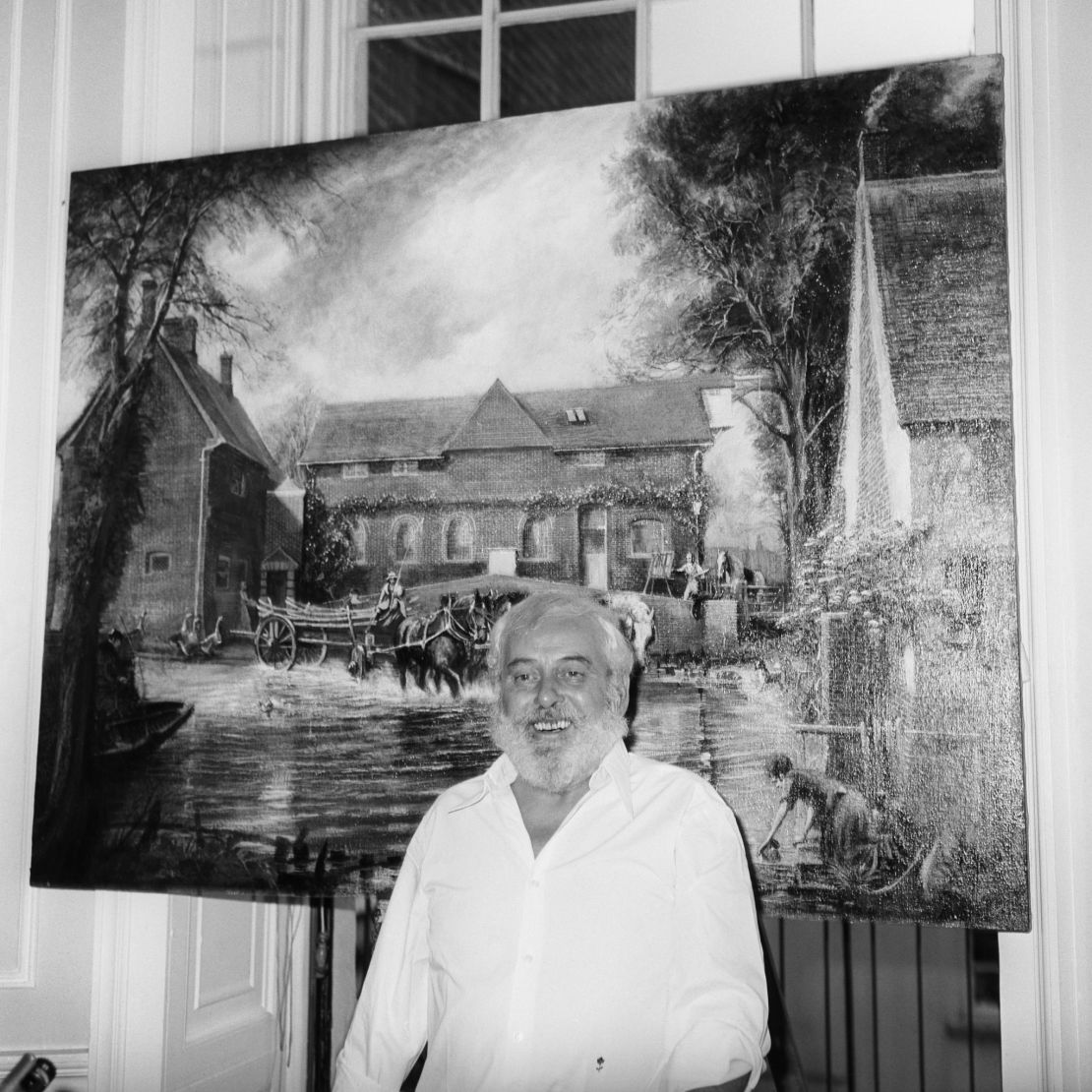 Artist Tom Keating standing in front of one of his works, his impression of Constable painting 'The Haywain', at a press conference in London. He admitted flooding the market with imitation paintings as a protest against art "merchants."