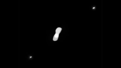 Kleopatra (center) is shown with its moons AlexHelios and CleoSelene, which are the two small white dots (top right and bottom left).