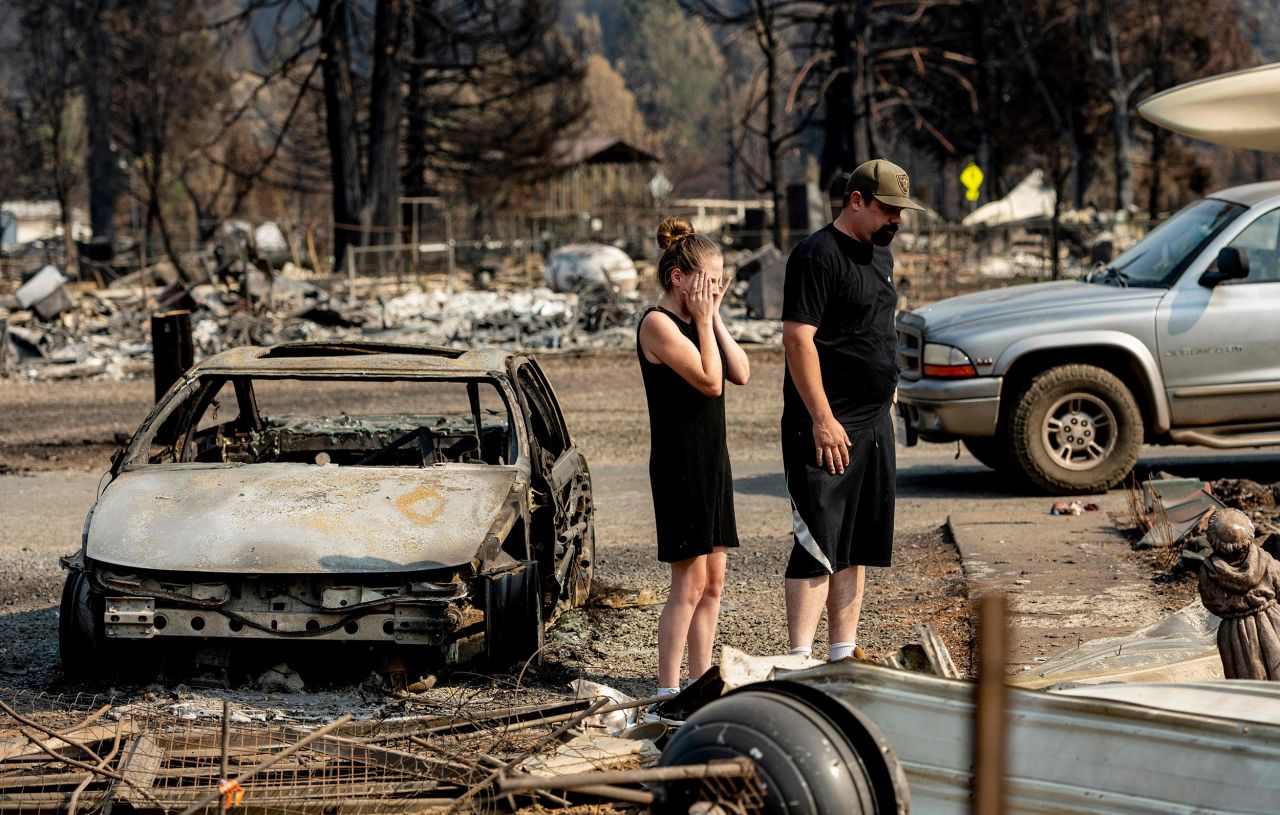 Riley Cantrell cries while she and  boyfriend, Bradley Fairbanks, view what's left of her mother's home in Greenville, California, on September 4. It was destroyed by the Dixie Fire.