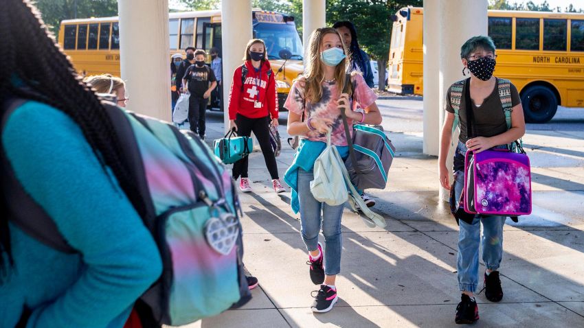 Students arrive by bus for the first day of school at Kernodle Middle School in Greensboro, N.C., on Monday, Aug. 23, 2021. The federal government has provided $190 billion in pandemic aid to schools since March 2020. This is more than quadruple what the U.S. Education Department spends on K-12 schools in a typical year. (Woody Marshall/News & Record via AP)