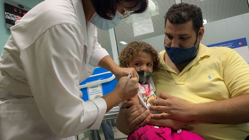 TOPSHOT - Pedro Montano holds his daughter Roxana Montano, 3, while she is being vaccinated against COVID-19 with Cuban vaccine Soberana Plus, on August 24, 2021 at Juan Manuel Marquez hospital in Havana, as part of the vaccine study in children and adolescents. (Photo by ADALBERTO ROQUE / AFP) (Photo by ADALBERTO ROQUE/AFP via Getty Images)