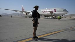A Qatari security personnel stands guard near a Qatar Airways aircraft at the airport in Kabul on September 9, 2021. - Some 200 passengers, including US citizens, were set to leave Kabul airport on September 9, 2021, on the first flight carrying foreigners out of the capital since a US-led evacuation ended on August 30. (Photo by Wakil Kohsar / AFP) (Photo by WAKIL KOHSAR/AFP via Getty Images)