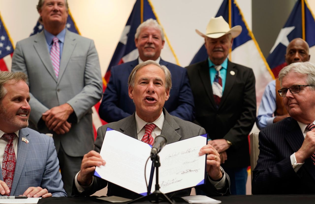 Texas Gov. Greg Abbott shows off his signature after <a href="https://www.cnn.com/2021/09/07/politics/texas-greg-abbott-voting-bill/index.html" target="_blank">signing a bill </a>Tuesday, September 7, that bans 24-hour and drive-thru voting, imposes new hurdles on mail-in ballots and empowers partisan poll watchers.