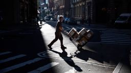 A United Parcel Service Inc. (UPS) worker crosses Williams Street near the New York Stock Exchange (NYSE) in New York, U.S., on Monday, Nov. 9, 2020. Stocks surged around the world and bonds tumbled after a large-scale coronavirus vaccine study delivered the most-promising results in the battle against the worst pandemic in a century. Photographer: Michael Nagle/Bloomberg via Getty Images