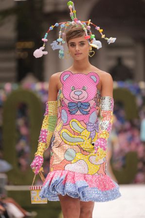 Model Taylor Hill walks the runway at Moschino wearing a mobile headdress and teddy bear-printed cocktail dress.
