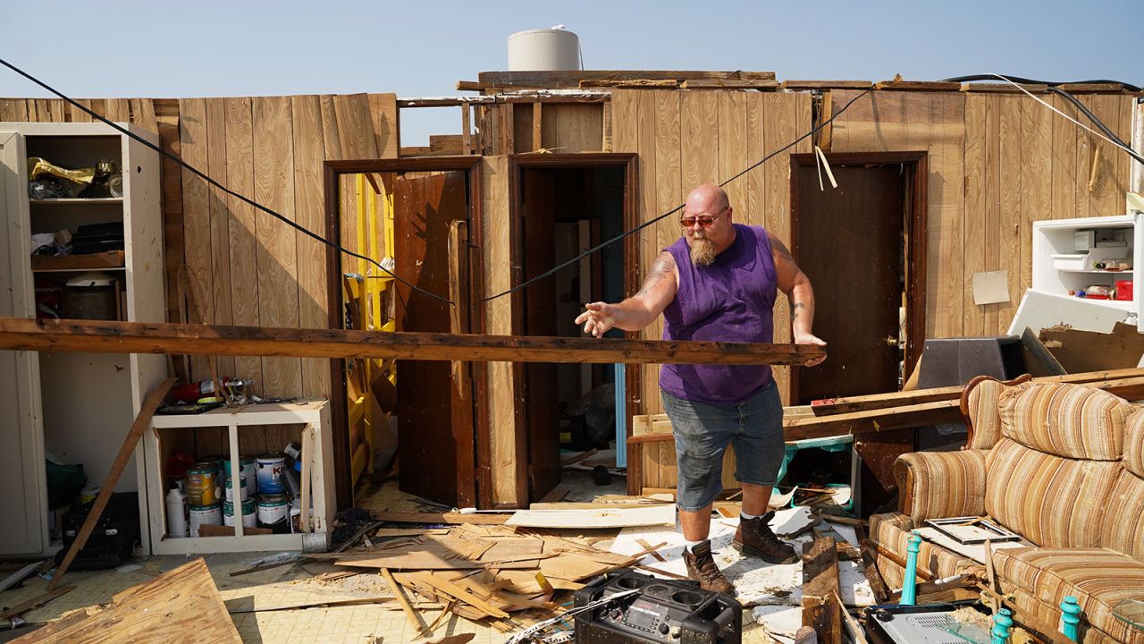Greg Knight tosses a wooden beam at his storm-damaged house in Grand Isle, Louisiana.