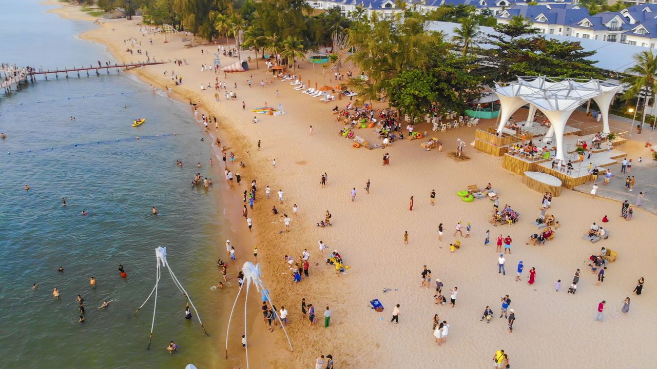Aerial view of Sunset in Phu Quoc beach with nice view. Tourists, sunbeds and umbrellas on beautiful day in Sanato beach, Phu Quoc island, Vietnam. Travel concept.