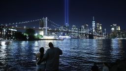 People watch as the Tribute In Light shines into the sky from Lower Manhattan during a test on September 07, 2021 as seen from the Brooklyn borough of New York City. Honoring the victims of the September 11, 2001 attack that killed almost 3,000 people at the World Trade Center, the Tribute in Light is a commemorative public art installation that was first presented six months after 9/11 and then every year since on the anniversary. New York City is preparing to mark the 20th anniversary of the September 11 terrorist attacks.  (Photo by Chip Somodevilla/Getty Images)