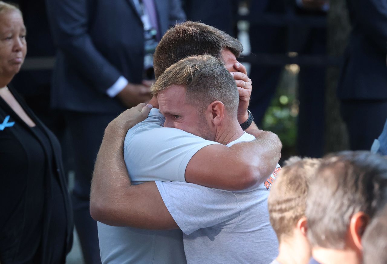 Mourners embrace during the ceremony in New York.
