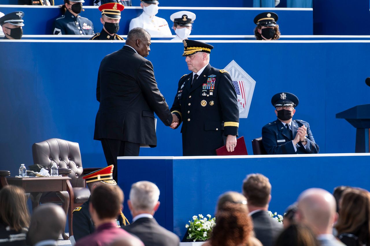 Defense Secretary Lloyd Austin, left, and Chairman of the Joint Chiefs of Staff Gen. Mark Milley greet each other during the ceremony at the Pentagon.