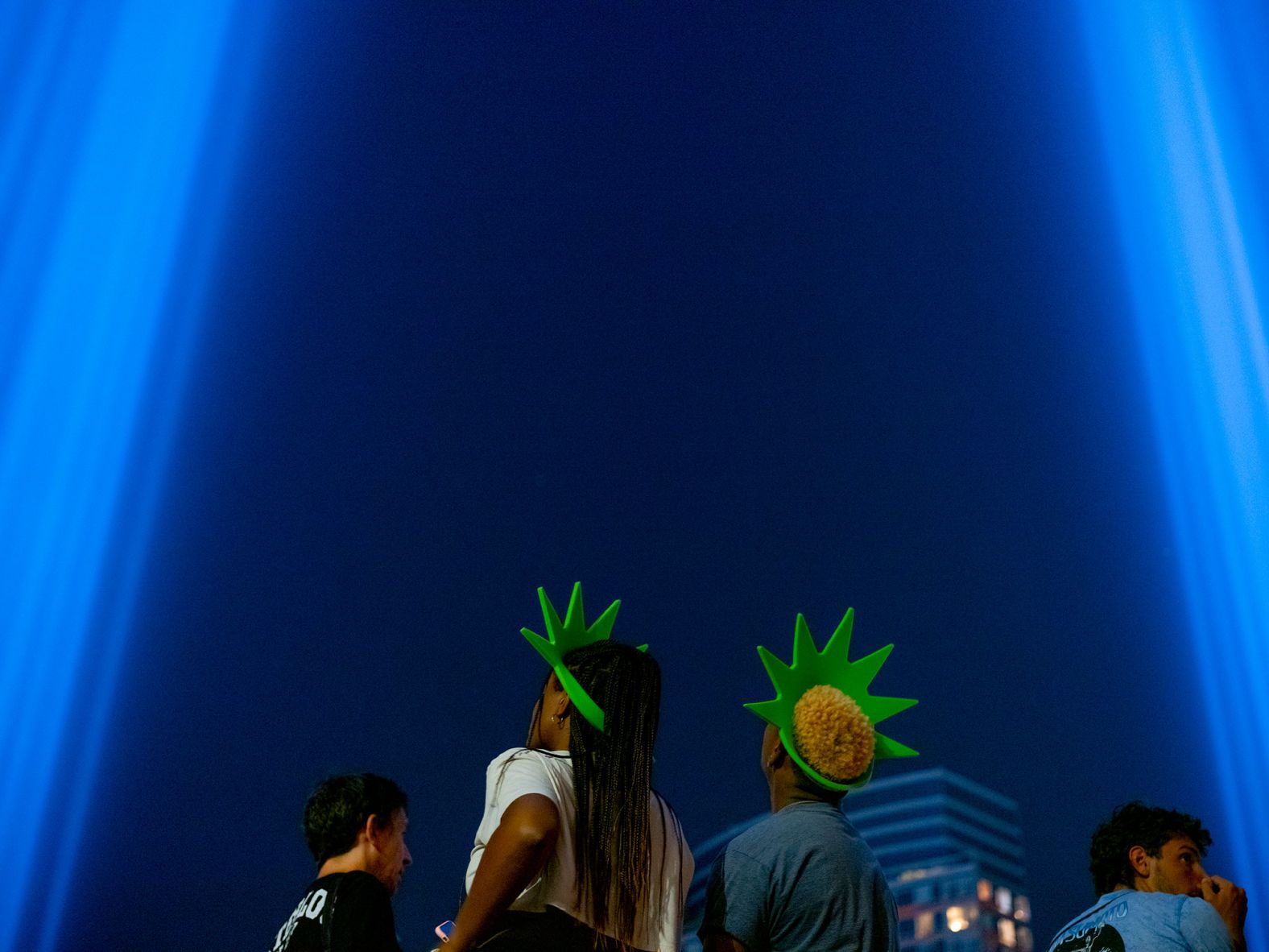 People observe the Tribute in Light memorial in New York from the top of a parking garage.