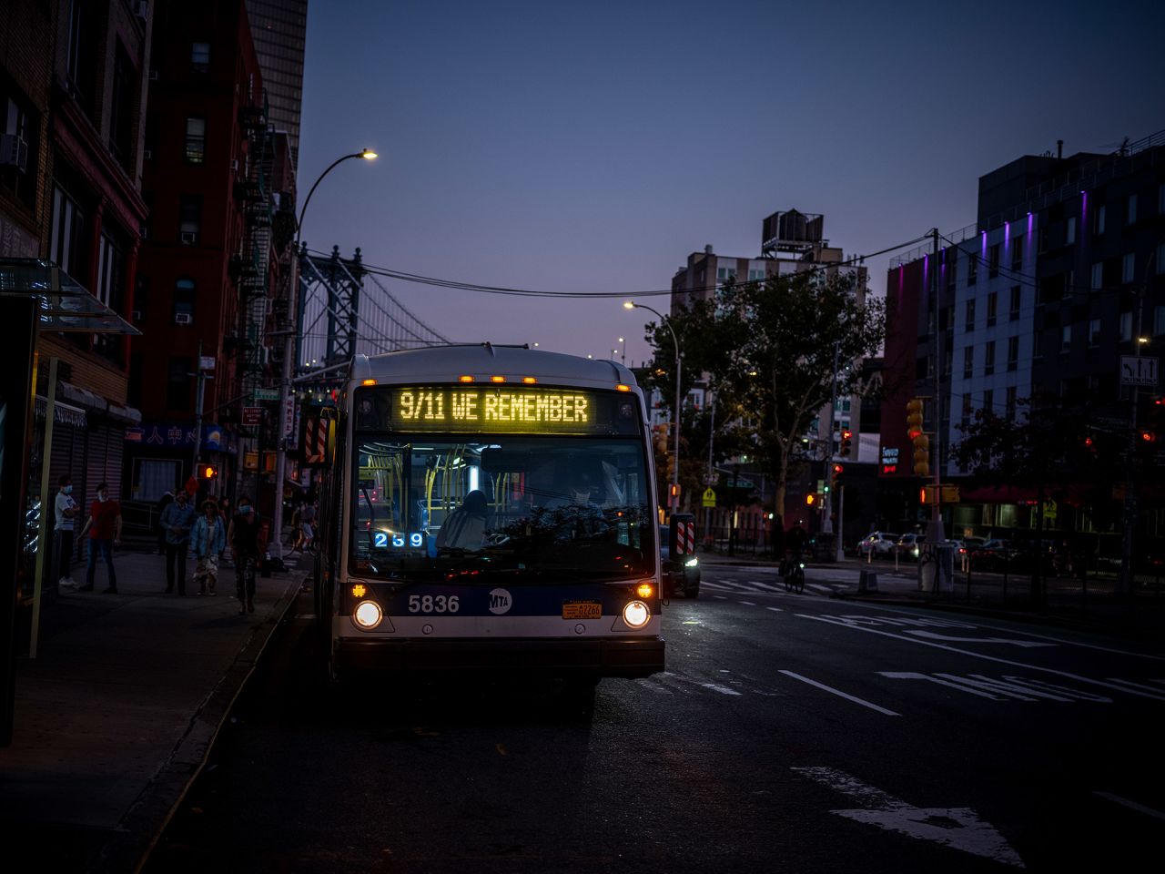 A bus makes its way through New York's Chinatown. The destination sign was changed to read "9/11 We Remember."