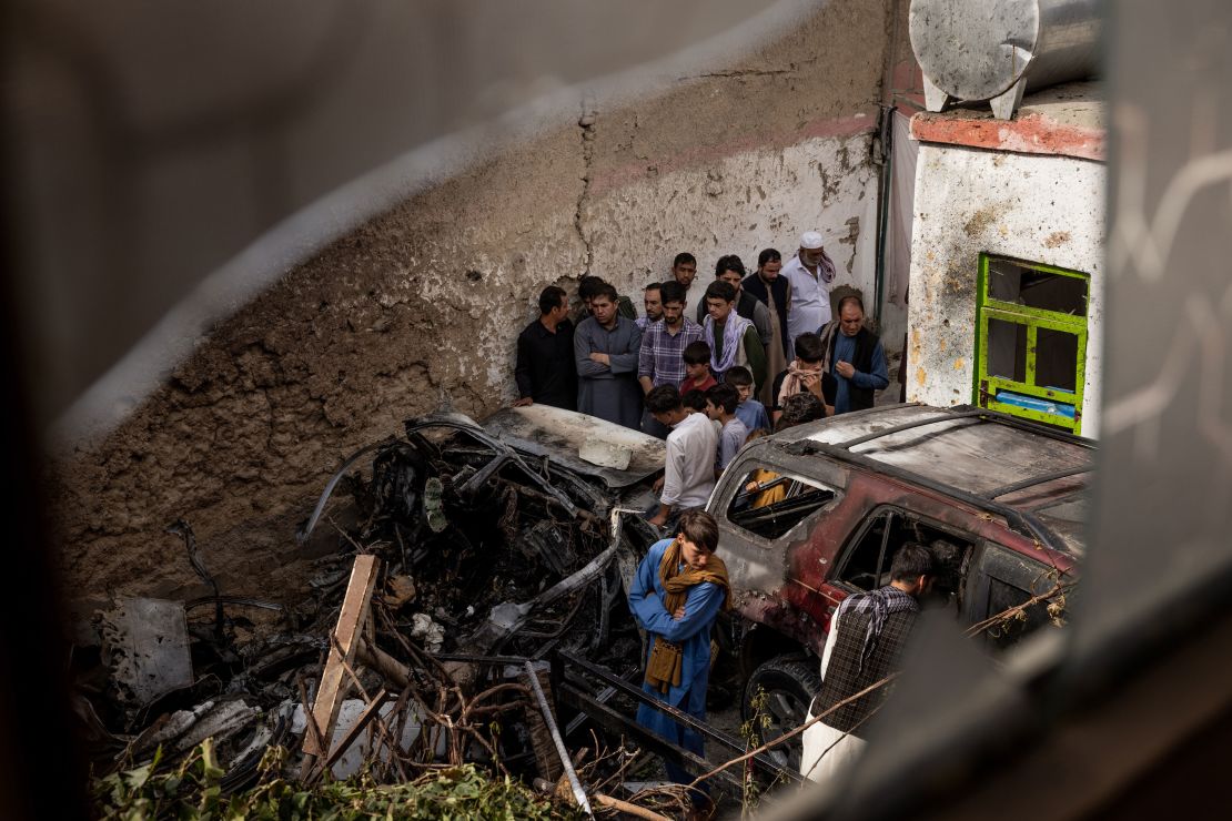Relatives and neighbors inspect the remains of the US Hellfire missile strike in the residential compound in Kabul.