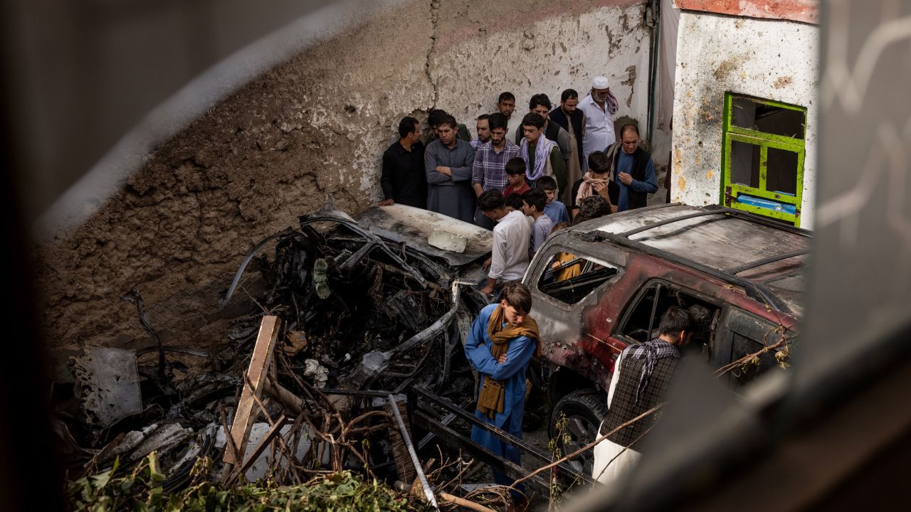 Relatives and neighbors inspect the remains of the US Hellfire missile strike in the residential compound in Kabul.