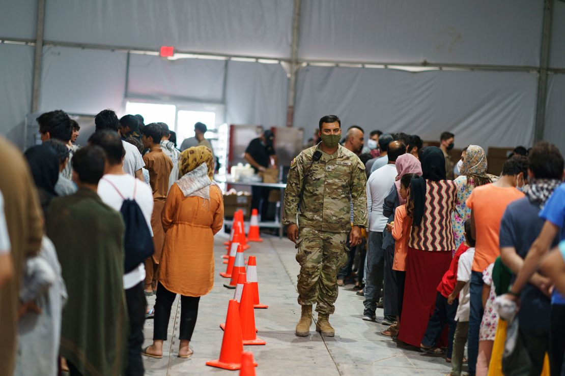 Afghan refugees line up for food in a dining hall at Fort Bliss' Doña Ana Village where they are being housed in Chaparral, N.M., Friday, Sept. 10, 2021. 